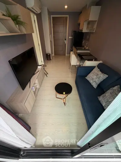 Modern living room with sleek furniture and open kitchen layout in a stylish apartment.