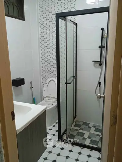 Modern bathroom with geometric tiles and glass shower enclosure