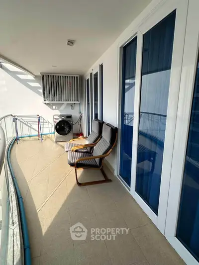 Spacious balcony with seating and modern design in a high-rise apartment.