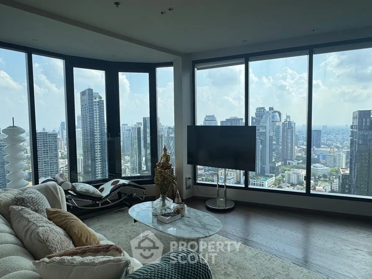 Luxurious living room with panoramic city views and modern decor in high-rise apartment.