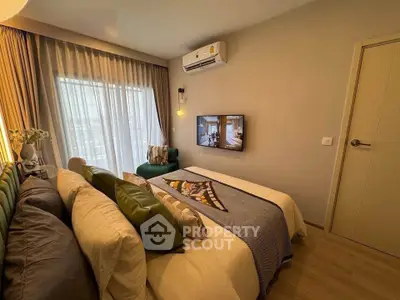 Cozy bedroom with modern decor and large window offering natural light