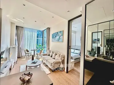 Modern living room with elegant decor and natural light, adjacent to a stylish bedroom.