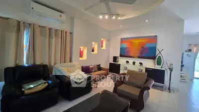 Spacious living room with modern decor and vibrant artwork, featuring comfortable seating and ample natural light.