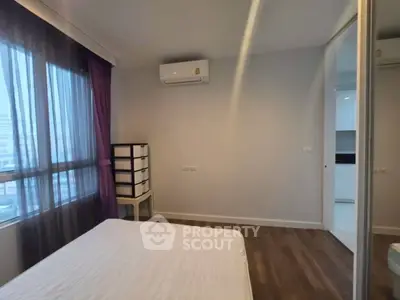 Modern bedroom with air conditioning and wooden flooring in a stylish apartment.