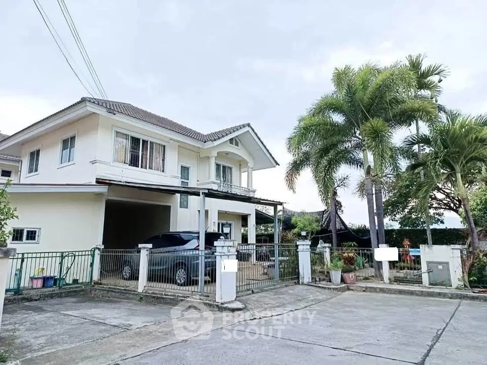 Spacious two-story house with driveway and lush palm trees in a serene neighborhood.