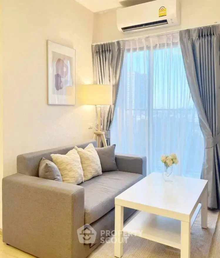 Cozy living room with modern sofa, stylish decor, and large window with city view.
