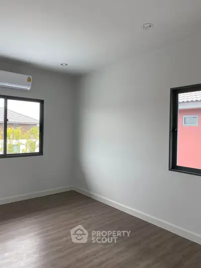 Bright and airy bedroom with modern flooring and large windows in a contemporary home.