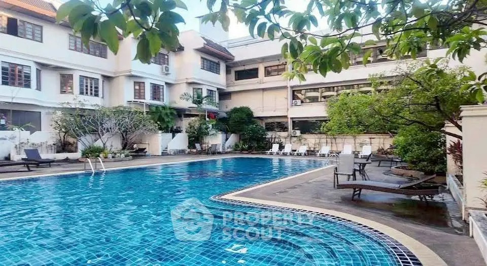 Luxurious residential pool area with lush greenery and elegant architecture.