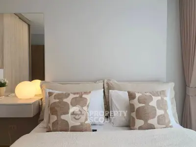 Cozy bedroom with stylish pillows and soft lighting, perfect for relaxation and comfort.