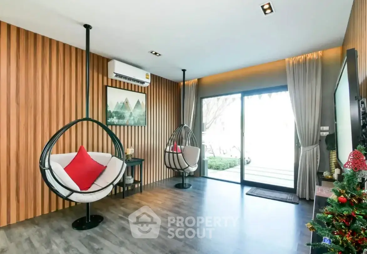 Modern living room with stylish hanging chairs and wooden accent wall