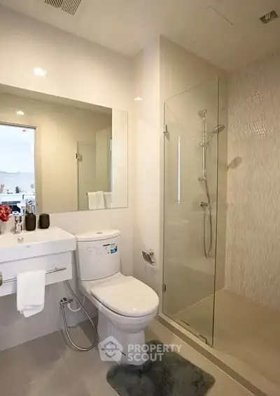 Modern bathroom with glass shower and sleek fixtures in a contemporary home.