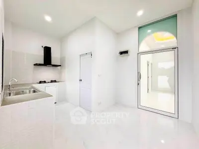 Bright modern kitchen with sleek design and gas stove in a minimalist home.