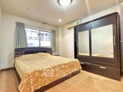 Spacious bedroom with elegant decor and large wardrobe in a modern apartment.