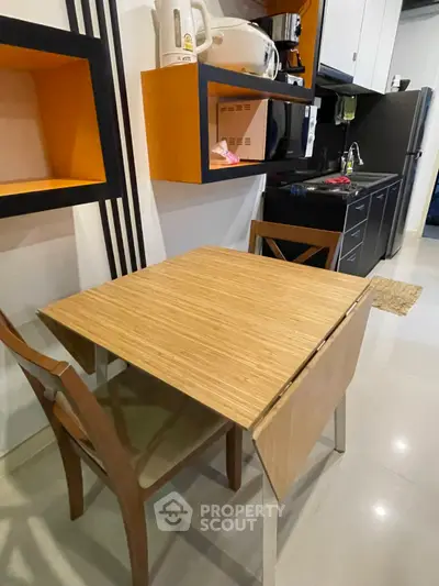Modern kitchen with compact dining area and sleek appliances