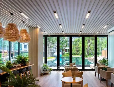 Luxurious living room with pool view, modern decor, and abundant natural light.