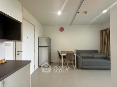 Modern apartment interior with sleek kitchen and cozy living area featuring a sofa and dining table.