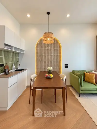 Modern open-layout kitchen and living room with stylish decor and warm lighting.
