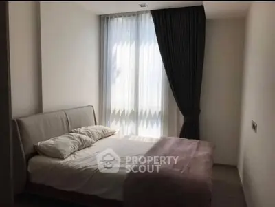 Cozy bedroom with natural light and elegant curtains, perfect for relaxation.