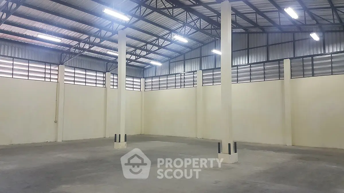 Spacious industrial warehouse with high ceilings and ample natural light, perfect for storage or manufacturing needs.