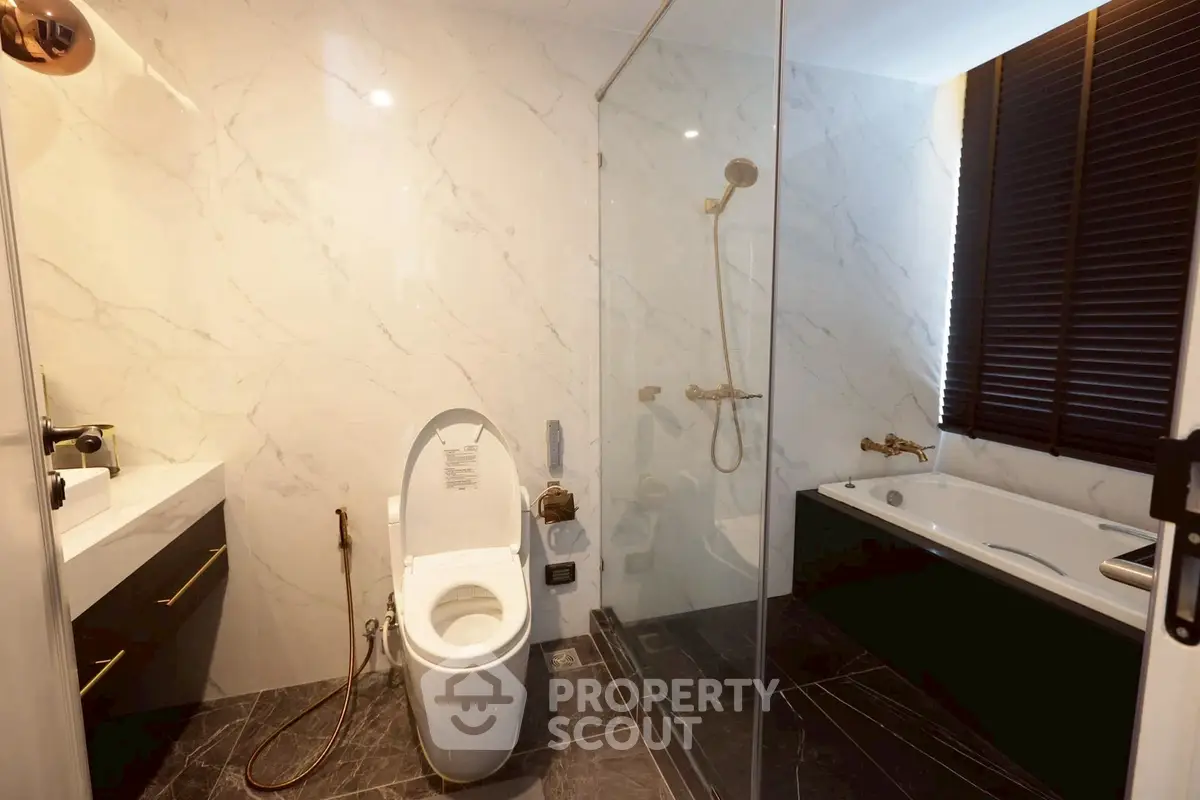 Luxurious modern bathroom with marble walls and glass shower enclosure