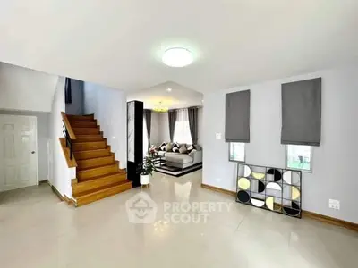 Spacious modern living room with stylish decor and wooden staircase