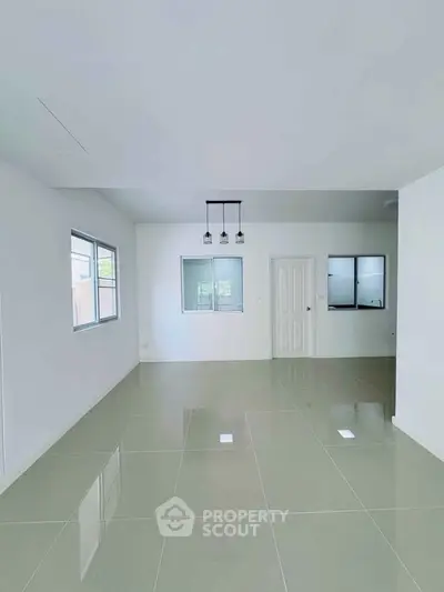 Spacious modern living room with glossy tiled floors and large windows