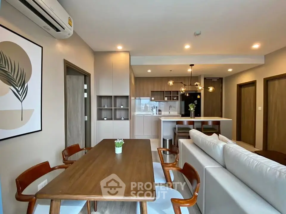 Modern open-plan living room and kitchen with stylish furniture and elegant lighting.
