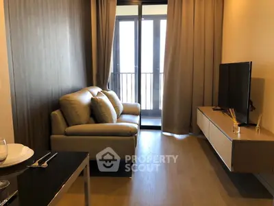 Modern living room with cozy sofa and flat-screen TV near balcony