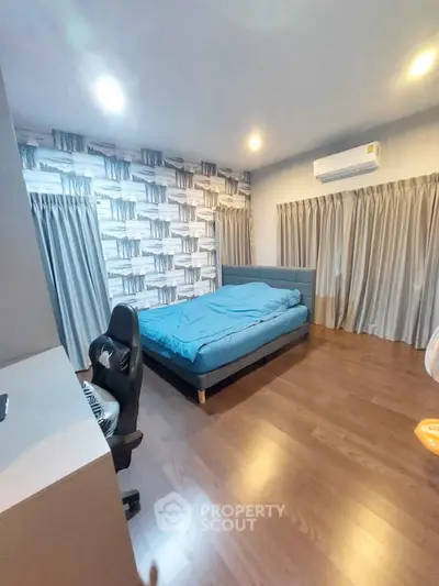 Spacious bedroom with modern decor and wooden flooring, featuring a cozy bed and stylish wallpaper.