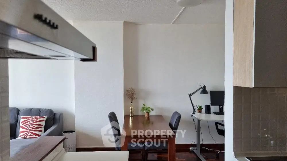 Modern open-plan living space with a cozy dining area and a well-equipped work station, perfect for professionals.