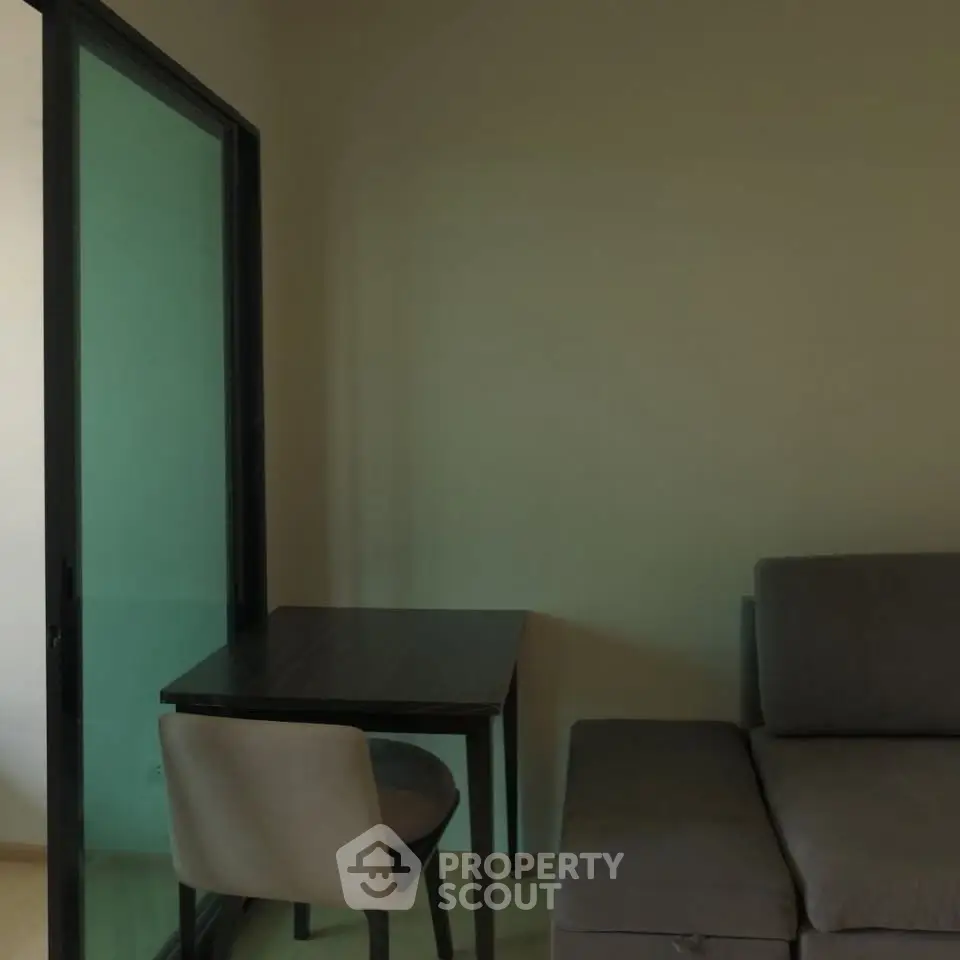 Cozy living room with modern sofa and compact dining table, perfect for urban living.