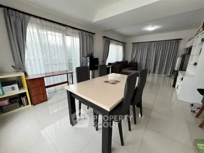 Spacious living room with elegant dining area and large windows