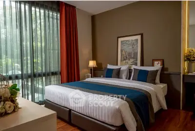 Luxurious bedroom with elegant decor and large window offering natural light.
