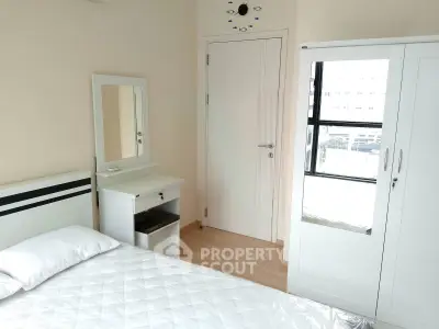 Bright and cozy bedroom with modern white furniture and ample natural light.