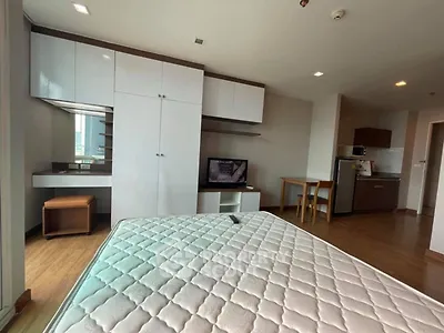 Modern studio apartment with sleek furnishings and compact kitchen area.