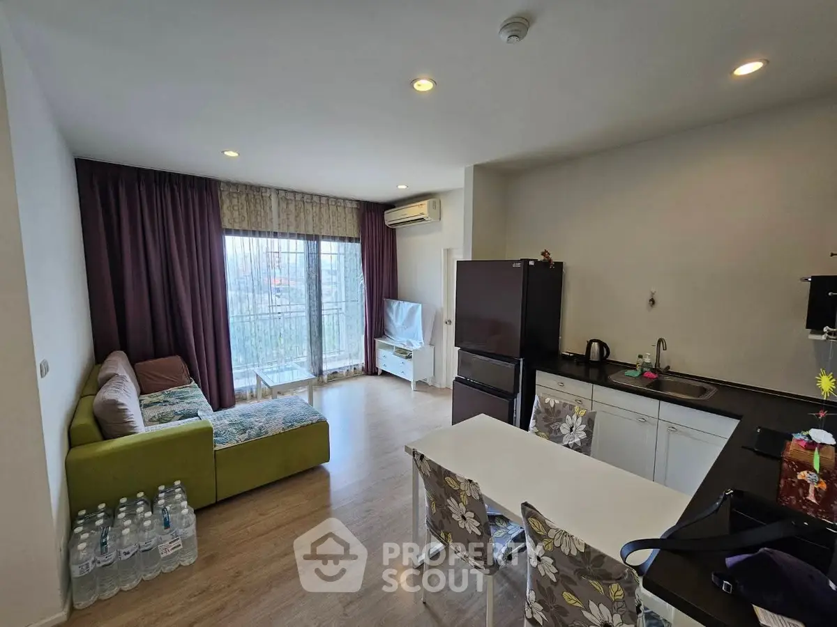Modern living room with open kitchen, featuring sleek design and natural light.