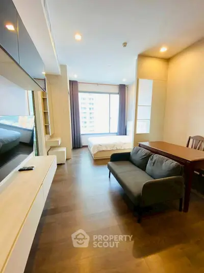 Spacious modern studio apartment with large window and stylish furnishings