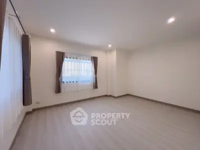 Spacious empty room with large window and elegant curtains, perfect for customization.
