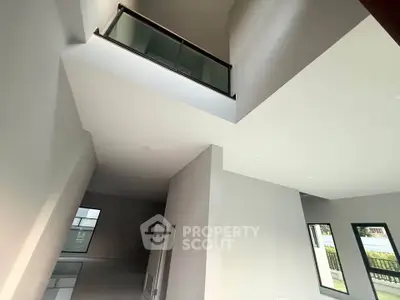 Spacious modern interior with high ceilings and large windows, offering abundant natural light and open space.