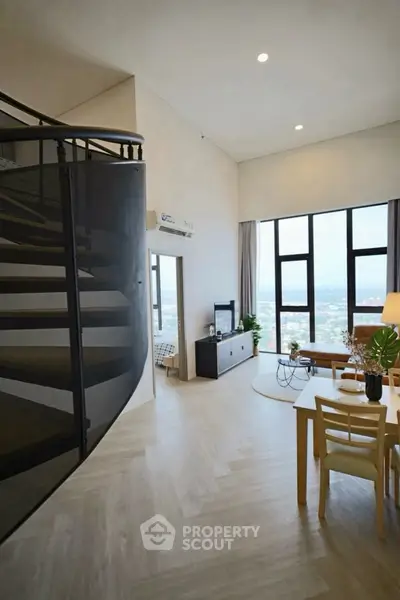 Spacious modern living room with high ceilings and city view, featuring a spiral staircase and elegant decor.