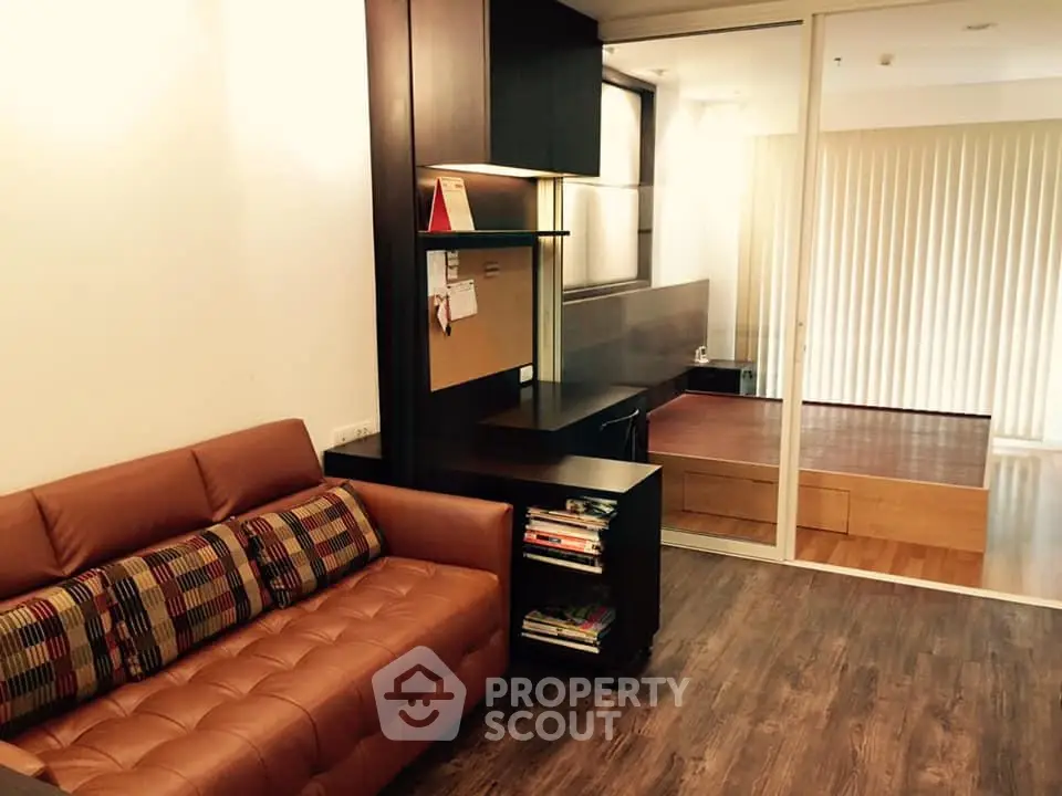 Modern living room with stylish brown leather sofa and wooden flooring, featuring a cozy study nook.