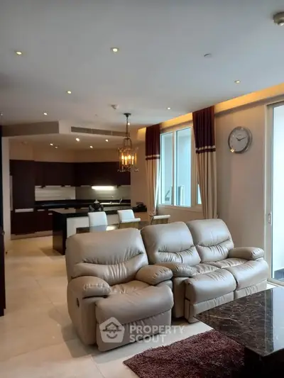 Luxurious open-plan living room with plush seating and modern kitchen