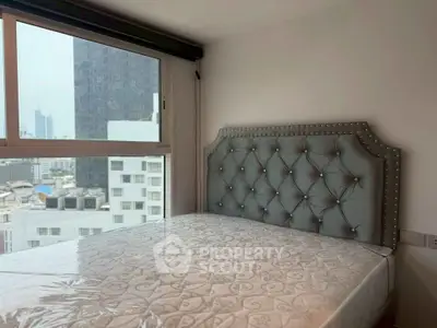 Modern bedroom with elegant tufted headboard and city view window.