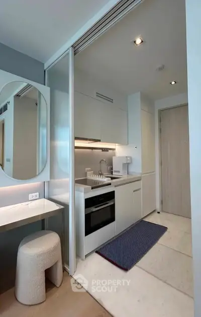 Modern compact kitchen with sleek design and integrated appliances in a stylish apartment.