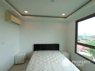 Modern bedroom with large window and air conditioning unit, offering a bright and airy atmosphere.