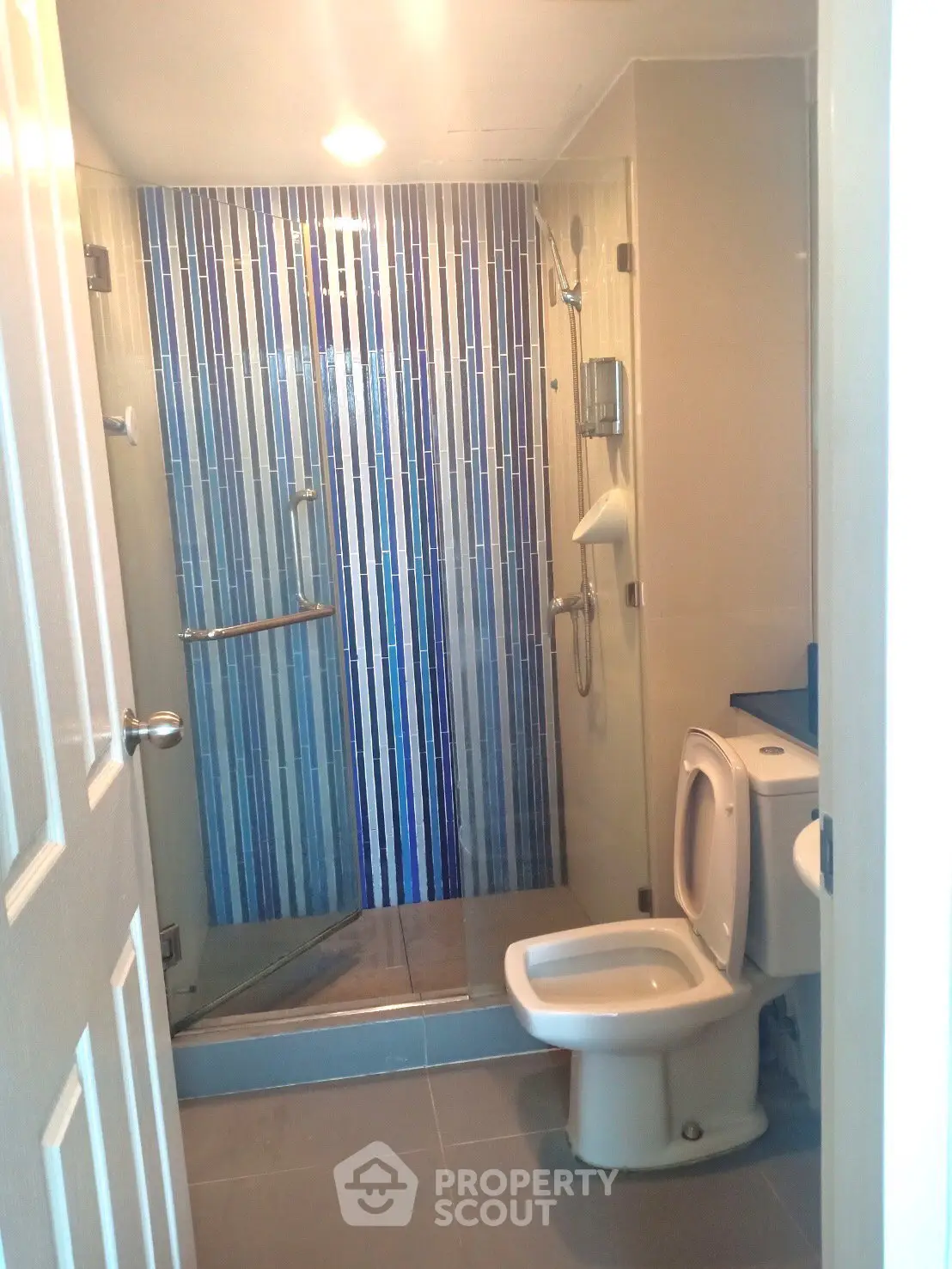 Modern bathroom with glass shower and blue tile accents