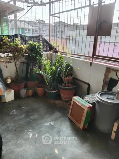 Charming balcony with potted plants and urban view, perfect for relaxation and gardening enthusiasts.