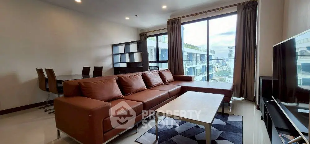 Spacious modern living room with city view, brown leather sofa, and dining area.