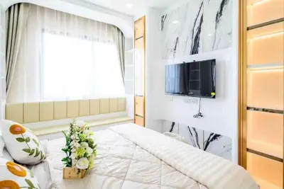 Luxurious bedroom with modern decor, large window, and wall-mounted TV in a stylish apartment.