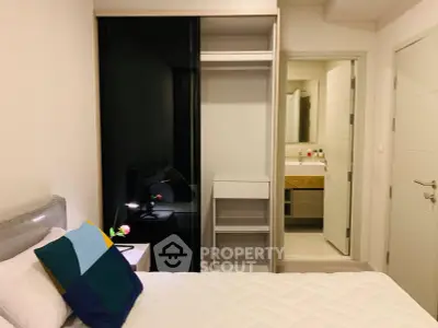Cozy bedroom with modern closet and ensuite bathroom in stylish apartment.